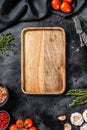 Wooden cutting board in center of Fresh raw greens, vegetables. Healthy, clean eating, vegan, dieting food concept. Black Royalty Free Stock Photo