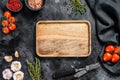 Wooden cutting board in center of Fresh raw greens, vegetables. Healthy, clean eating, vegan, dieting food concept. Black Royalty Free Stock Photo
