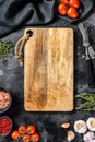 Wooden cutting board in center of Fresh raw greens, vegetables. Healthy, clean eating, vegan, dieting food concept Royalty Free Stock Photo