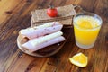 Wooden cutting board with crispbread, cheese, ham, cherry tomato, glass of fresh orange juice on a wooden background Royalty Free Stock Photo