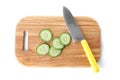 Wooden cutting board with cucumber slices and chef`s knife isolated on white Royalty Free Stock Photo