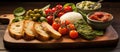 A wooden cutting board with a variety of vegetables, bread, and plum tomatoes Royalty Free Stock Photo