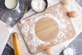 Wooden cutting board dusting with flour for dough.Empty round spot for text on the cutting board.Kitchen table and flour,eggs,salt Royalty Free Stock Photo