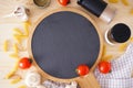 Wooden cutting board and fresh ingredients for cooking: pasta, tomato and spices over wooden table background. Flat lay Royalty Free Stock Photo