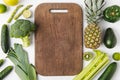Wooden cutting board with green vegetables and fruits isolated on white background Royalty Free Stock Photo