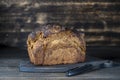 Wooden cutting board with a loaf of black bread and knife on wooden table Royalty Free Stock Photo