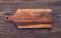 Wooden cutting board on old wooden table, top view