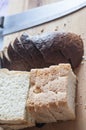 Wooden cutting board with sliced white bread and knife on wooden table Royalty Free Stock Photo