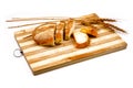 Wooden cutting board with sliced white bread and spike on white background Royalty Free Stock Photo