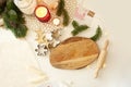 Wooden cutting Board, a small rolling pin, tree branches, burning candles and metal cookie cutters on a beige light Christmas Royalty Free Stock Photo
