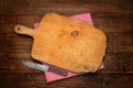 A wooden cutting board with a vintage rural knife. Background.