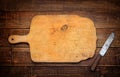 A wooden cutting board with a vintage rural knife. Background.