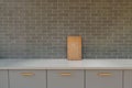 Wooden cutting board on a white kitchen cabinet leaning onto a wall with grey tiles Royalty Free Stock Photo