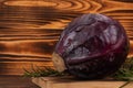 Wooden cutting board with whole purple cabbage and rosemary on rustic background Royalty Free Stock Photo