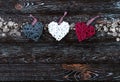 Wooden dark background with Christmas wicker balls in the form of a heart in white, red gray colors with bokeh