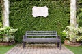 Wooden dark brown bench and blank vintage card against green lea Royalty Free Stock Photo