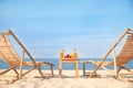 Deck chairs near table with fruits and drinks on beach Royalty Free Stock Photo