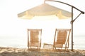 Wooden deck chairs, outdoor umbrella and table with cocktails on sandy beach. Royalty Free Stock Photo