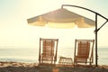 Wooden deck chairs, outdoor umbrella and table with cocktails on sandy beach. Summer vacation Royalty Free Stock Photo