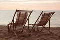 Wooden deck chairs on beach at sunset. Summer vacation Royalty Free Stock Photo