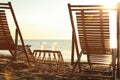 Wooden deck chairs and wicker table with cocktails on sandy beach. Summer vacation Royalty Free Stock Photo