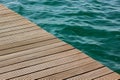 Wooden deck floor background texture diagonal line and vivid blue and green water with small waves on a surface in big swimming Royalty Free Stock Photo