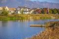 Wooden deck on lake with homes and mountain view Royalty Free Stock Photo