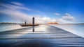 Wooden deck on the lakeside during spectacular passing cumulus clouds over water Royalty Free Stock Photo