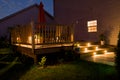 Wooden deck and patio of family home at night.