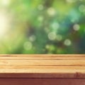 Wooden deck table with garden bokeh background. Ready for product display montage. Royalty Free Stock Photo