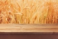 Wooden deck table over wheat field background