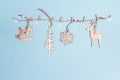 Wooden decorations hang on clothespins on blue background with c