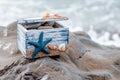 Wooden decorative Chest with sea shells and blue star on the sea coast Royalty Free Stock Photo