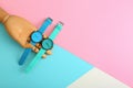 Wooden decorative hand and stylish wrist watches on color background. Space for text