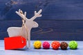 Wooden deer winter holiday decoration with tag for price on dark wooden background. Decorations for Christmas holidays Royalty Free Stock Photo