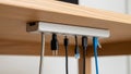 A wooden desk with a cable management device attached beneath it Royalty Free Stock Photo