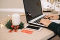 Wooden desk with Christmas candle and laptop