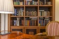 Wooden desk and classic bookcase with books Royalty Free Stock Photo