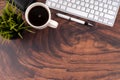 Wooden desk with coffee, pen and computer keyboard flat lay Royalty Free Stock Photo