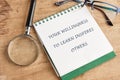 On a wooden desk, a notepad displays an inspiring message about learning and its impact on others. Beside the notepad
