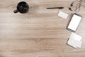 Wooden desk with smartphone, headphones, name tag, pen, black co Royalty Free Stock Photo