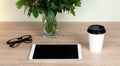 Wooden Desk. White tablet with black-rimmed glasses. White Cup of coffee Royalty Free Stock Photo