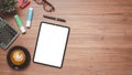 Wooden desk workplace with blank screen digital tablet for product display, calculator, eyeglass, pen and cup of coffee, Top view Royalty Free Stock Photo