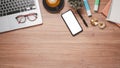 Wooden desk workplace with blank screen digital tablet for product display, calculator, eyeglass, pen and cup of coffee, Top view Royalty Free Stock Photo