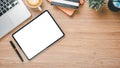 Wooden desk workplace with blank screen tablet, laptop, pen, notebook and cup of coffee Royalty Free Stock Photo