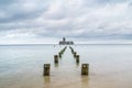 Wooden destroyed breakwaters line and ruins of torpedownia on Baltic Sea.