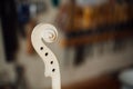 Wooden detail of the head of the violin. Raw wood, texture. Against the background of workshop.
