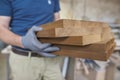 Wooden details in hands of male carpenter, woodworking industry Royalty Free Stock Photo