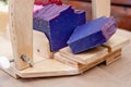 Wooden device for cutting soap handmade with a freshly cut purple bar of soap. Close up