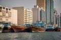 Wooden dhow cargo boats in Dubai Creek, modern buildings in the background, UAE